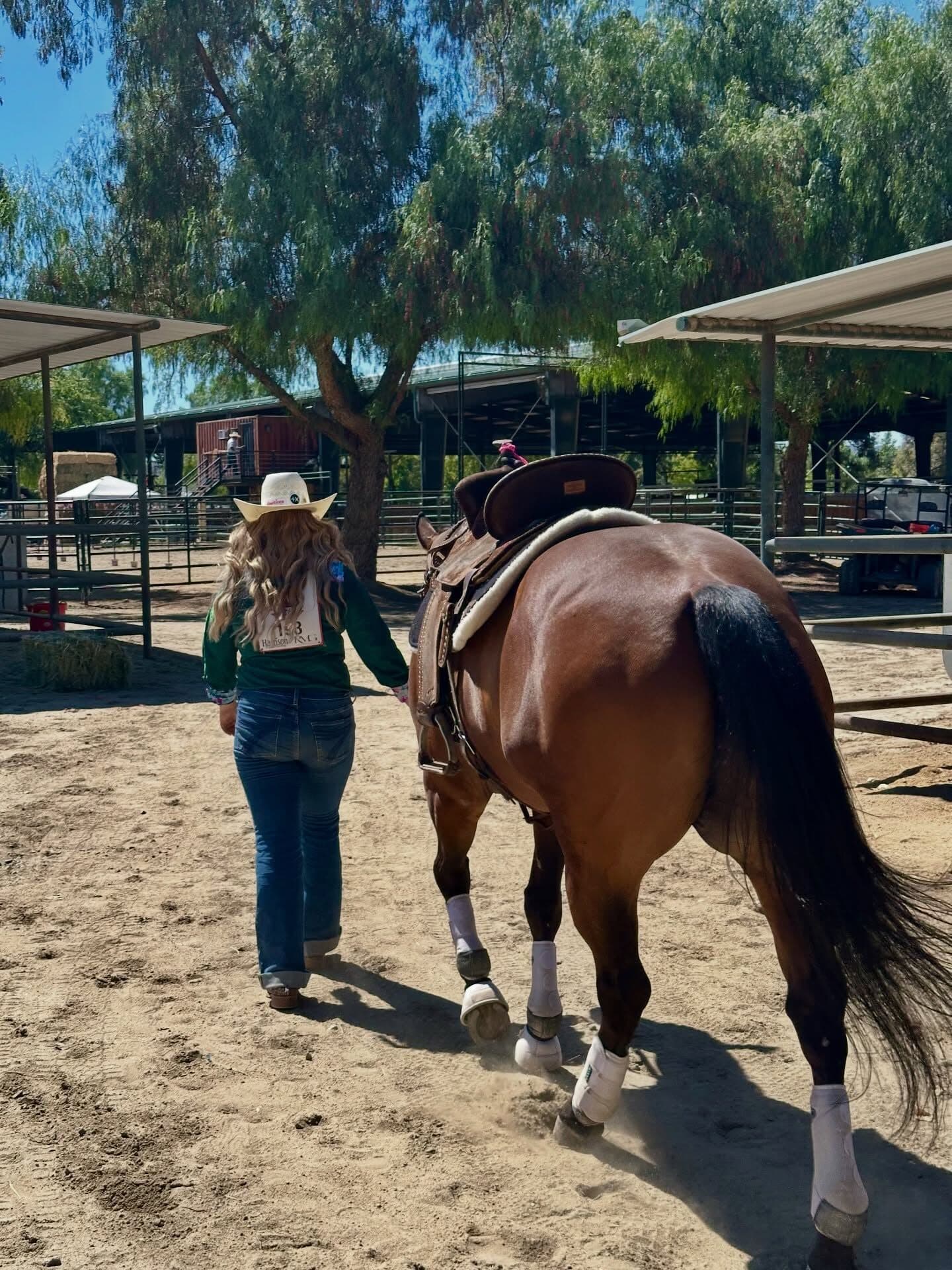 Remy Slobodian leading a tacked horse down the barn road